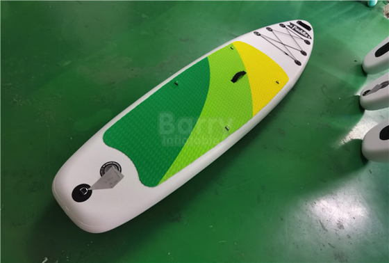 Il bordo gonfiabile verde e giallo su misura del SUP sta su Paddleboard