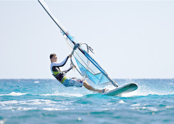 Il bordo gonfiabile del SUP del PVC degli sport acquatici sta sul bordo di pagaia fa windsurf